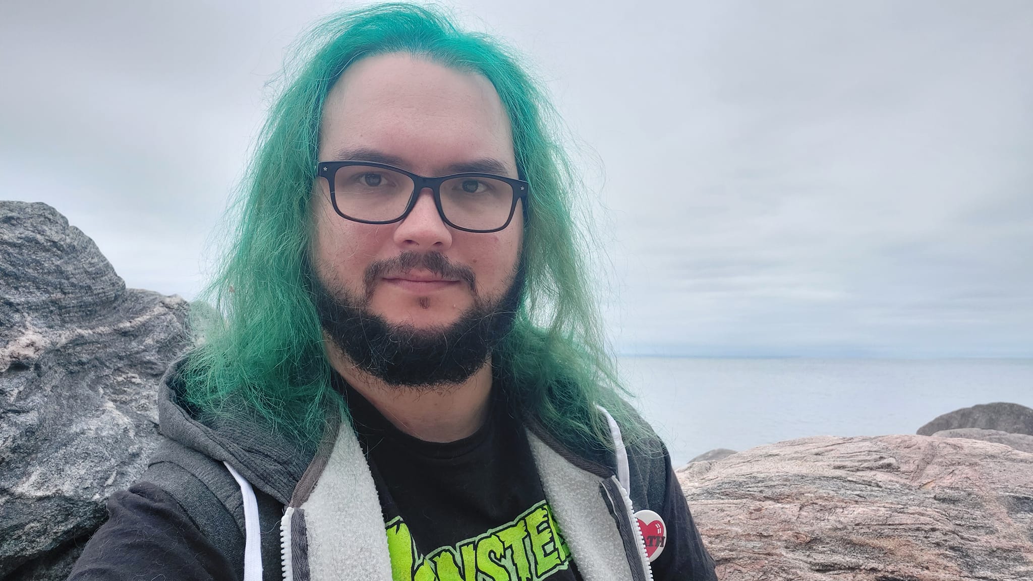 A man with green hair stands outside at a boulder breakwater, photo 18